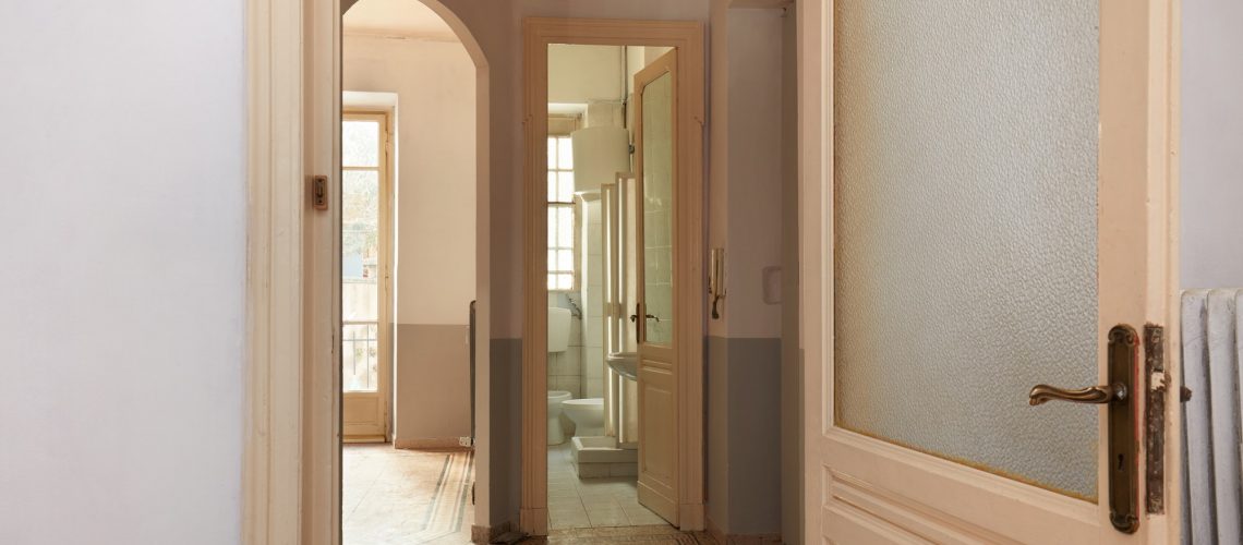 Old apartment interior view with open wooden door