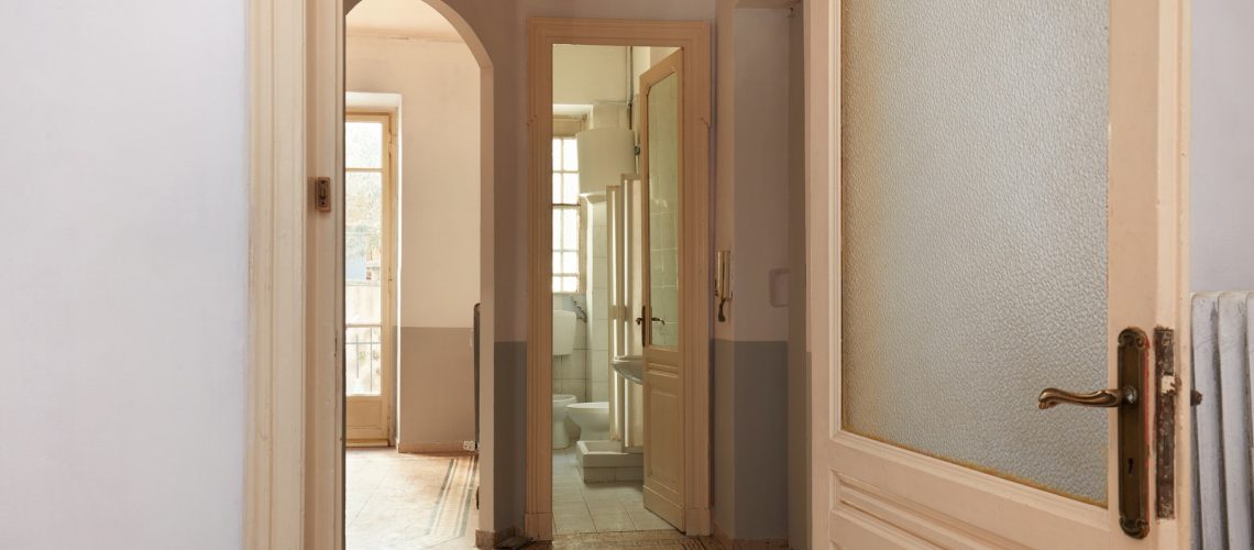 Old apartment interior view with open wooden door